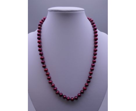 A red pearl bead necklace with a 14 ct gold clasp. 44 cm long. 