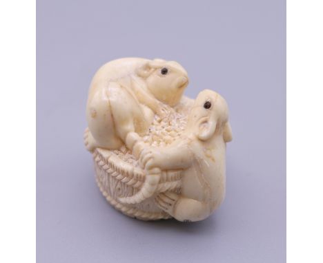 A carved bone netsuke formed as rats on a barrel. 3 cm high.