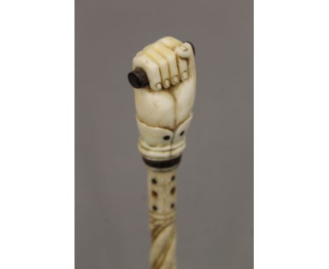 A 19th century carved whalebone walking stick with carved ivory clenched fist handle. 80 cm long.