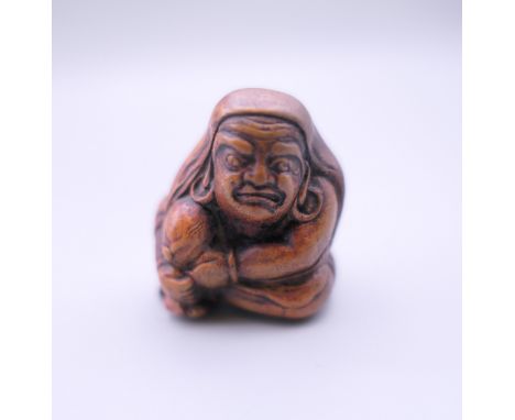 A Japanese netsuke formed as a seated man. 4 cm high.