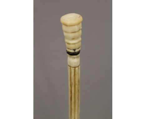 A 19th century carved whalebone walking stick with carved ivory handle. 83 cm long.