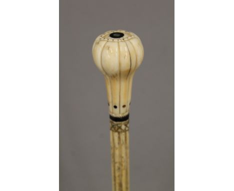 A 19th century carved whalebone walking stick with carved ivory handle. 91 cm long.