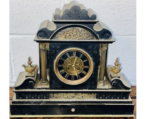 A slate mantel clock with gilded metal columns urns and a classical frieze