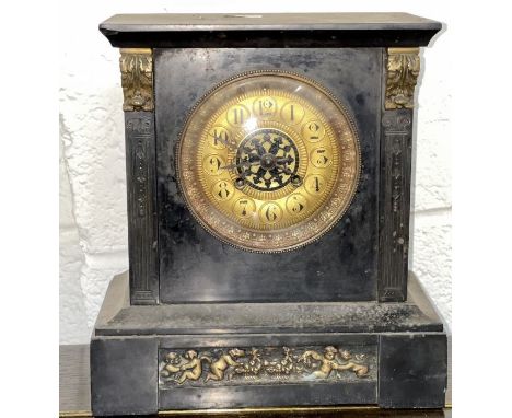 A slate and brass mantel clock with brass face and decorative panel