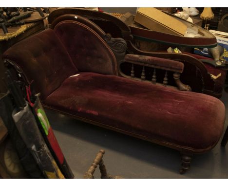 A victorian mahogany framed chaise lounge button back with velvet upholstery, on turned column supports and raised on castors