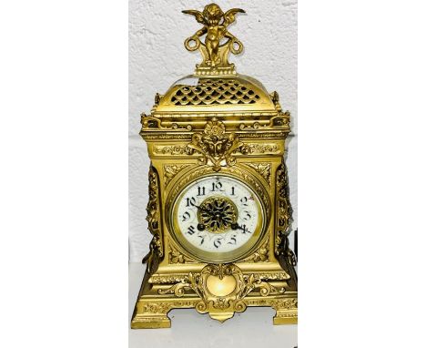 A heavy cast ornate mantel clock with cherub.