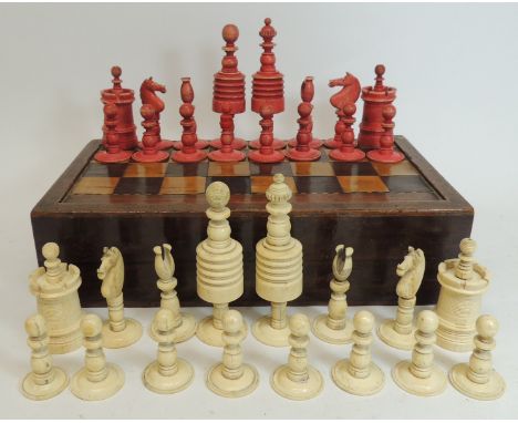 A complete 19th Century turned bone chess set, white and stained red, contained in a 19th Century marquetry inlaid games box 