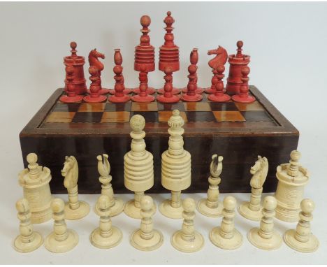 A complete 19th Century turned bone chess set, white and stained red, contained in a 19th Century marquetry inlaid games box 