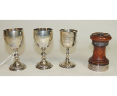 An oak and silver banded peppercorn grinder.  Hallmarked for Chester 1907, a pair of small silver egg cup style trophies with
