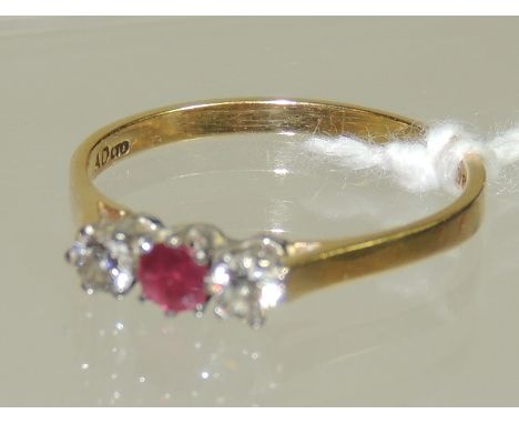 A ladies 18ct gold diamond and ruby ring set with a central ruby with a diamond to either side.  Ring size P+.  