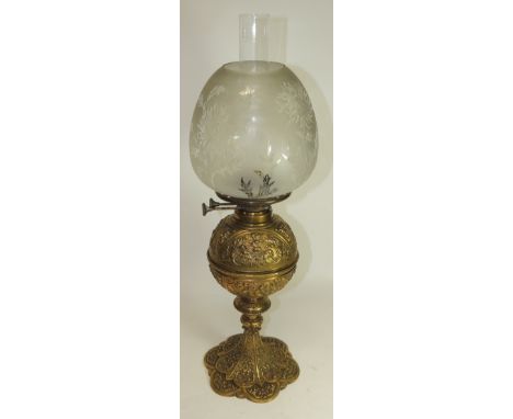 A Victorian decorative brass oil lamp cast with satyr masks, cornucopia and scrolling foliage; the glass reservoir fitting in