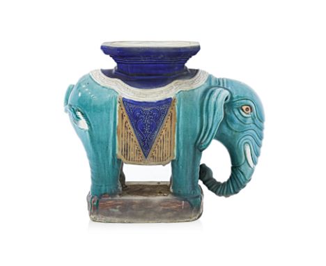 A CERAMIC ELEPHANT PLANT STAND
Slip-moulded pottery, cobalt-blue, turquoise and amber glaze, standing upright with trunk curl