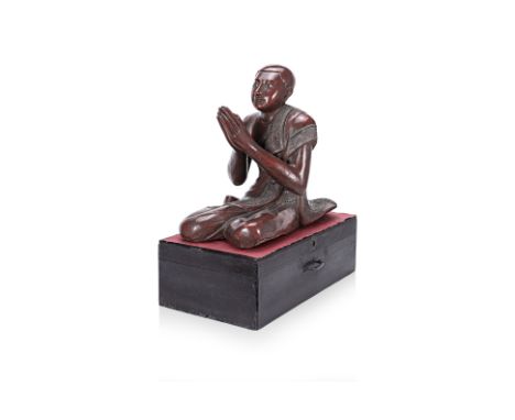 A BURMESE KNEELING MONK
Carved and red lacquered timber, the kasaya robe with inset red and clear mirror glass disc border, o