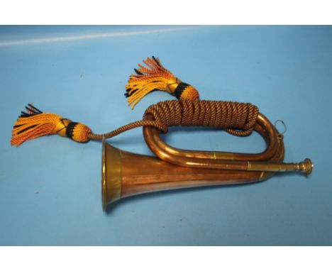 A COPPER AND BRASS BUGLE with black and gold braided lanyard