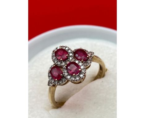 A Lovely example of a ladies 9ct gold diamond and ruby ring. Consists of four oval cut rubies surrounded by diamonds. [Ring s