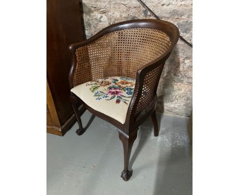 Antique bergere tub chair designed with a tapestry removable cushion seat. Designed with ball and claw feet. 