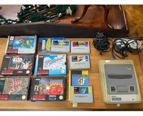 A Vintage Super Nintendo Snes console with various boxed and unboxed games. Games Include Star Wars, Doom, Super Mario World 