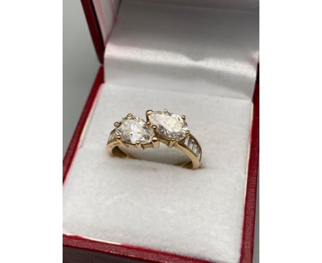 A Nice example of a ladies 9ct gold evening ring designed with two CZ tear drop stones off set by cushion cut CZ Shoulders. [