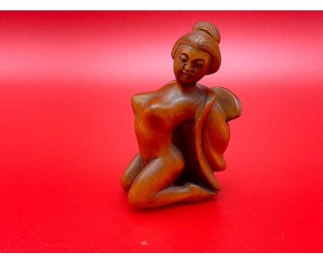 A Japanese hand carved netsuke of a nude geisha figure. Signed by the artist. 