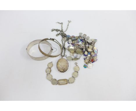 A quantity of silver and enamel charms, silver bangles and a locket on chain, etc (a lot) 