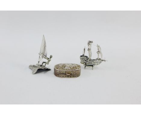 Novelty silver wind surfing figure, silver pirate ship and a  white metal snuff / pill box, tallest 7.5cm high (3) 