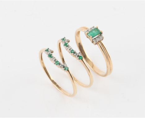 Three emerald and diamond rings, three interlocking rings, one ring has an emerald cut emerald to the centre with three round