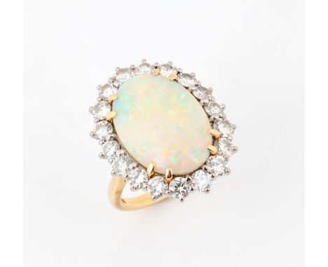 Opal and diamond dress ring, featuring an estimated 4.12 carat oval cabochon opal, in an eight claw setting, surrounded by ei