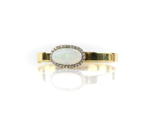 Opal and diamond hinged bangle, a large oval cabochon opal, estimated weight 5.74 carats, with a halo of old cut diamonds, es