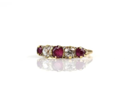 Antique ruby and diamond ring, three round cut rubies, with two old cut diamonds set in between, mounted in a carved hoop rin