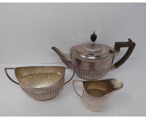 A three piece silver tea set, sugar, tea pot and milk jug, tea pot and helmet jug Ebony handle by William Hutton and Sons, 19