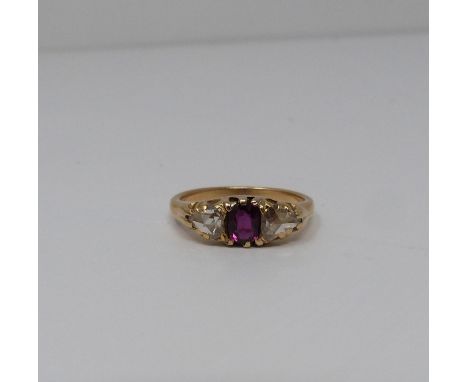 A three stone Ruby and rose cut diamond yellow metal ring, set to centre with a cushion shaped old cut ruby in a open back cl