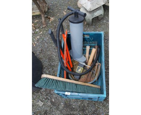 A plastic crate of gardening tools, air pump, two masonry hammers, brush head, axe head and loppers.