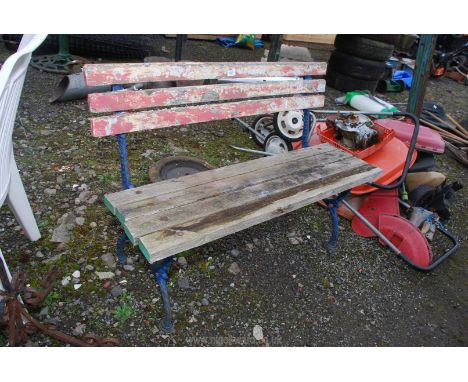 A wooden-slatted seated garden bench on cast iron legs/supports representing rustic fronds/branches. 43" long approx.