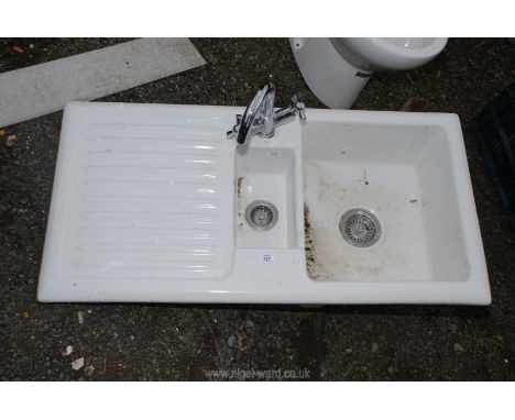 A one and a half bowl ceramic kitchen sink with mixer tap.