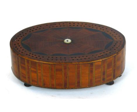A fine Regency inlaid cribbage board of oval form
Having various woods to include Satin, Kingwood, with base storage compartm