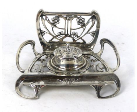 An Art Nouveau silver-plated desk stand
Having pierced floral decoration surrounding a central inkwell, height 11cm.
