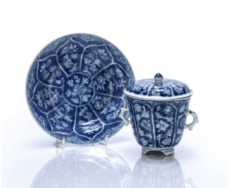Two-handled blue and white chocolate cup, saucer and coverChinese, Kangxidecorated with petal-shaped panels filled with flowe