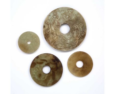 Four carved jade Bi discsChinese, 18th/19th Centurycomprising of a Longshan style disc carved on one side in low relief with 