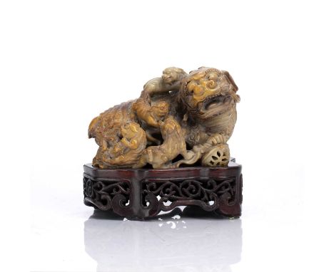 Soapstone model of a Buddhistic lion and cubsChinese, 19th Centurythe open mouthed lion with front foot resting on a ball, wi