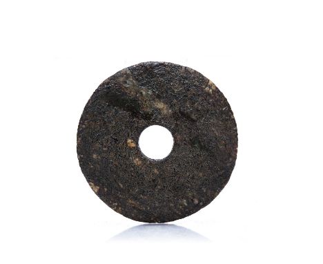 Jade Bi discChinese, 7th or 6th millennium BCErough weathered texture almost appearing to be fossilized, retaining a Bluett a