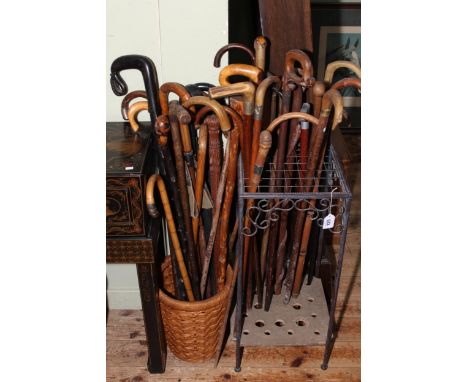 Collection of vintage walking sticks in a stick stand and basket.