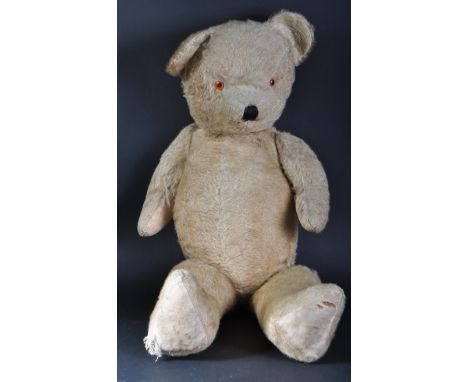 A large vintage English soft toy teddy bear, likely Chiltern or Chad Valley. Orange and black beaded eyes with stitched nose 