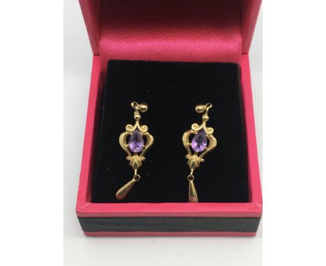 A pair of 9ct gold earrings set with a central amethyst
