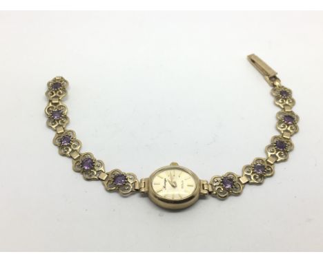 A ladies 9ct gold watch set with amethyst type stones, approx 10.8g.