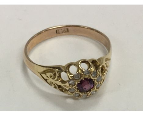 An 18ct gold ring inset with Ruby surrounded by diamonds. Size R