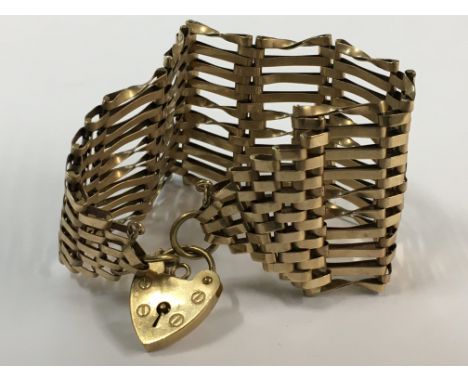 A gold gate bracelet with attached heart clasp. Weight 21g