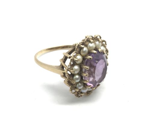 A 9ct gold ring set with a central amethyst surrounded by seed pearls, approx 5.4 g and approx size O.