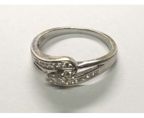 An 18carat white gold ring set with intertwined rows of brilliant cut diamonds with three central diamonds. Ring Size approx 