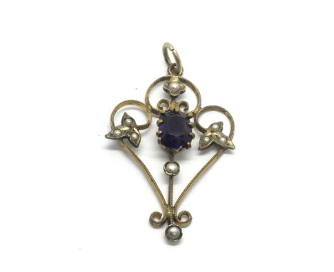 A yellow metal Art Nouveau pendant set with seed pearls and a central amethyst.