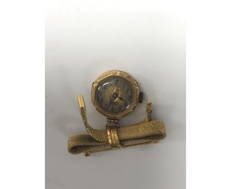 A gold ladies watch on a ribbon tie.